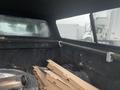 A 2015 GMC Sierra 1500 with a black bed liner showing debris and cardboard boxes inside the truck bed