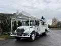 A 2007 International 4200 white utility truck with a bucket lift and a flatbed for tools and equipment