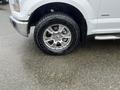 A close-up of the front wheel and tire of a 2016 Ford F-150 showcasing a chrome rim and detailed tread pattern on the tire