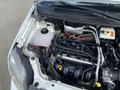 View of the engine compartment of a 2013 Ford Transit Connect featuring various mechanical components such as the engine block cooling system and hoses