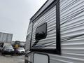 A side view of a 2021 Jayco Jay Flight travel trailer featuring horizontal metallic stripes and a window with a black frame