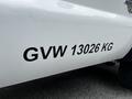 A close-up of a white 2011 Ford F-550 showing a sticker that reads GVW 13026 KG on the side panel