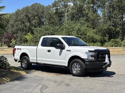 A white 2016 Ford F-150 pickup truck with black accents and chrome wheels parked on a street