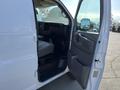 A 2014 Chevrolet Express van with the driver's side door open showcasing the interior and dashboard