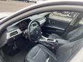 Interior view of a 2011 BMW 3-Series featuring a black leather driver's seat and dashboard with gauges and controls