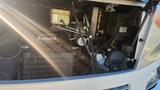Engine components of a 2007 Winnebago Adventure including hoses wires and a cooling system with sunlight streaming through
