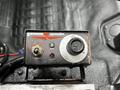 A control panel for a Swenson spreader featuring a power switch a green indicator light and a dial for adjusting settings