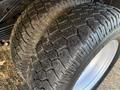 Close-up of two rugged tires with deep treads showcasing wear on a 2015 GMC Savana vehicle