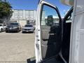 A 2020 Chevrolet Express van with the driver's side door open showing the interior features and seat