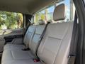 The interior of a 2020 Ford F-550 showing a back seat with two headrests and seatbelts in a light-colored fabric