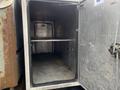 An open cargo compartment of a 2008 Mitsubishi Fuso FE180 with metal shelves and a clean interior showing no items inside