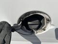 GMC Savana fuel cap and tether with a warning label saying tighten until one click