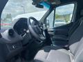 Interior view of a 2024 Mercedes-Benz Sprinter showcasing the steering wheel and driver's seat with a focus on the dashboard controls and seating upholstery