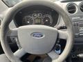 Steering wheel of a 2010 Ford Transit Connect with the Ford logo visible and control buttons on either side