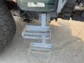 A close-up view of a Kubota M6040 tractor's two-step ladder attached to the cab for easy access