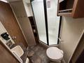 Interior view of a bathroom in a 2013 Outdoor Wind River featuring a shower stall toilet and sink with cabinets above