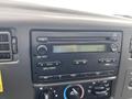 Close-up of the dashboard of a 2003 Ford F-450 SD showing the radio controls and display with buttons for volume, seek, and tuning