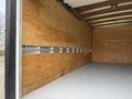 A 2022 Ford E-450 with an empty cargo area featuring wooden walls and metal support strips along the sides
