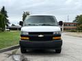 A white 2021 Chevrolet Express van facing directly towards the viewer with a black grille and headlights visible