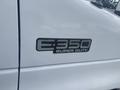 A white 2004 Ford Econoline van with an E-350 Super Duty badge on the side