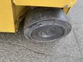 Close-up of a large black rubber wheel from a yellow 2010 Hyster S80XLBCS forklift showing wear and rough texture
