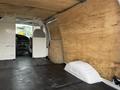 Interior view of a 2008 Ford Econoline van featuring wooden paneling and a rubber mat floor with a divider near the front seat area