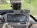 The dashboard of a 2005 Case 570 featuring various controls dials and gauges for operation including a radio and warning signs