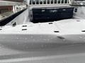 Close-up of a wet and textured surface of a white 2017 Ford F-250 SD truck bed with visible water droplets