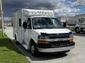 A white 2013 Chevrolet Express van with a boxy design and front grille featuring a prominent Chevrolet logo