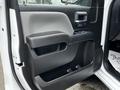 Interior door panel of a 2018 GMC Sierra 1500 featuring a black armrest and control buttons on the door handle area