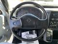 Steering wheel of a 2007 International 7300 with a dashboard full of gauges and controls visible in the foreground along with a thank you note on the floor