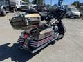 A 2004 Harley-Davidson FLHTCUI with a beige and chrome finish featuring saddlebags and chrome exhaust pipes parked sideways