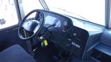 The interior dashboard of a 2011 Ford Econoline featuring the steering wheel various controls and a key in the ignition