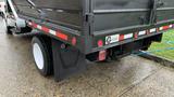 A 2021 International CV515 truck with a black cargo bed and red reflective stripes on the side, featuring a visible rear wheel and a mud flap.