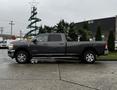 A 2020 RAM 3500 truck in a side view displaying its large body chrome wheels and prominent RAM emblem on the front doors