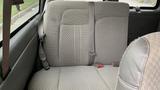 A rear bench seat in a Chevrolet Express Quigley 4x4 with a gray fabric design and seatbelts attached