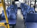 Interior view of a blue-seated 2017 Chevrolet Express bus showing several rows of seats with a clear aisle in the center