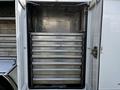A 2018 Ford F-550 with an open storage compartment featuring multiple metal sliding drawers for organized storage