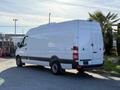 A 2016 Mercedes-Benz Sprinter van in white with a high roof and sliding side door parked on a street