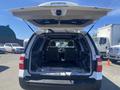 A 2013 Ford Expedition with its rear hatch open revealing an empty interior and foldable seats
