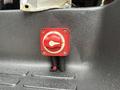 A red power cutoff switch mounted on a black surface with a dial to turn off or on