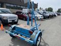 A blue 2003 U-Built Reel Trailer with a raised metal pole and equipment on top, featuring a large platform and wheels for towing