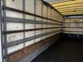 Interior of a 2006 Hino 268 box truck showing wooden slats and metal framework along the walls with a rubber mat floor