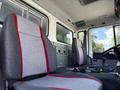 Interior view of a 1994 Volvo FE 42 featuring two gray and red upholstered seats with armrests and a simple dashboard layout