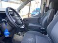 Interior of a 2022 Ford Transit showing the driver's seat steering wheel and dashboard with a blue air freshener hanging from the rearview mirror