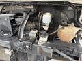 A close-up view of the engine compartment of a 2012 Ford Econoline showing various components including hoses and fluid reservoirs