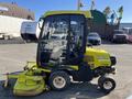 A 2010 Kubota F3990 lawn mower with a yellow and black exterior features a cab, a large mowing deck in front, and four wheels for mobility