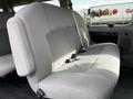 A grey fabric bench seat of a 2014 Ford Econoline with seat belts visible and a simple design