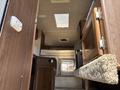 Interior view of a 2018 Westland Travelaire featuring a compact layout with cabinets a bed area and a staircase leading to the entrance