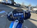 A 2017 Harley-Davidson FLHXS with a shiny blue finish featuring a detailed instrument panel and chrome handlebars